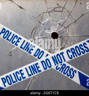 Bullet Hole und Police Tape. Stockfoto