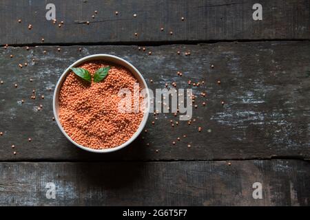 Draufsicht auf rote Linsen oder Masoor KI dal in einer Schüssel auf dunklem Holzhintergrund. Stockfoto