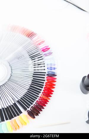 Nahaufnahme der farbenfrohen Nagellackpalette auf dem weißen Tisch im Nagelstudio Stockfoto