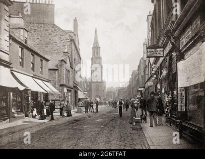 Eine Ansicht aus dem späten 19. Jahrhundert von Falkirk, einer großen Stadt in den Central Lowlands von Schottland, historisch innerhalb der Grafschaft Stirlingshire. Die geschäftige High Street mit Geschäften führt zum Falkirker Turm, der 1814 erbaut wurde und einen früheren Turm aus dem späten 17. Jahrhundert ersetzte, der selbst ein noch früheres Bauwerk ersetzte. Stockfoto