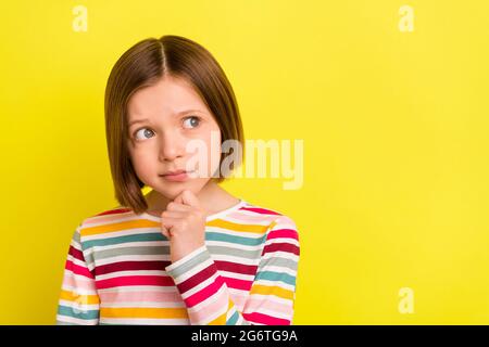 Foto von schweren jungen gesinnten kleinen Mädchen suchen leeren Raum smart Stellen Sie sich isoliert auf gelben Hintergrund Stockfoto