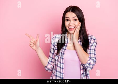 Portrait von attraktiven erstaunt fröhlich Mädchen demonstrieren Kopie leeren Raum ad isoliert über rosa Pastellfarben Hintergrund Stockfoto