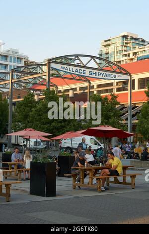 Menschen entspannen sich im Freien in der Shipyards Commons Community Development in North Vancouver, British Columbia, Kanada Stockfoto