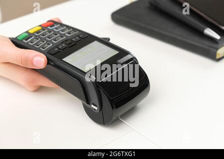 Weiblicher Hand-POS-Terminal für kontaktloses Bezahlen. Stockfoto