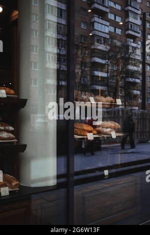 Schaufenster einer kleinen Bäckerei in einer Moskauer Straße. Reflexion im Fenster Stockfoto