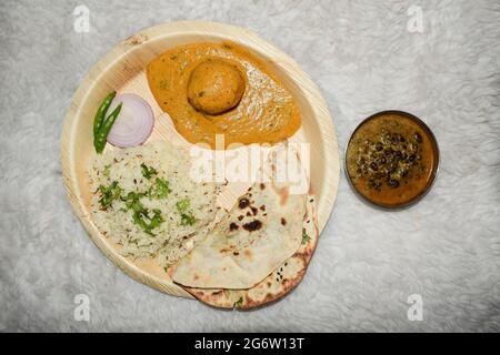 Indische hausgemachte Mahlzeiten zum Abendessen oder Mittagessen Jeera Reis, malai kofta, dal makhani, Butter naan mit Zwiebeln und grün kühl. Leckere nordindische einfach Stockfoto