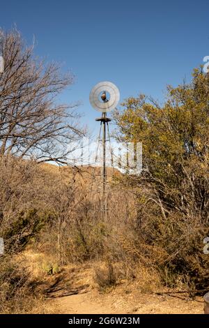 Wasserpumpe Windmühle dreht sich am Breezy Desert Day im Big Bend National Park Stockfoto