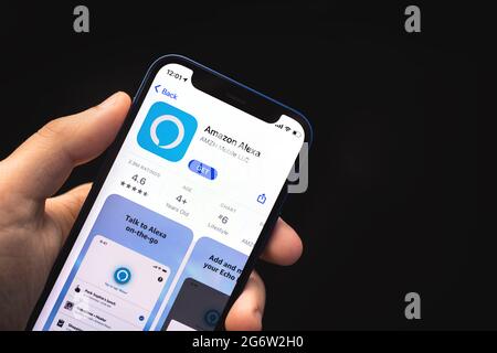 Kharkov, Ukraine - 4. Juni 2021: Mann benutzt Amazon Alexa App, Handy in der Hand Stockfoto