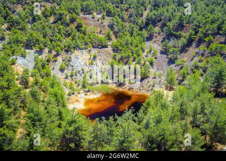 Wiederaufforstung eines alten Kupferminengebiets in der Nähe von Kinousa, Zypern. Der Rote See ist ein Ergebnis der Pyriterzgewinnung in diesem Gebiet Stockfoto