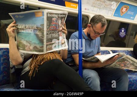 London, Großbritannien, 8. Juli 2021: Die englische Fußballmannschaft der Männer ist bis zum EM 2020-Finale durchgekommen und dominiert die Vorder- und Rückseite der Zeitungen, wie ein Paar im Londoner Underground liest. Eine ganzseitige Easyjet-Anzeige hofft, Kunden zu locken, die ab dem 19. Juli die Lockerung der Quarantäneregeln für Amber List-Länder nutzen könnten. Anna Watson/Alamy Live News Stockfoto