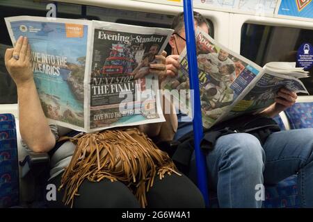 London, Großbritannien, 8. Juli 2021: Die englische Fußballmannschaft der Männer ist bis zum EM 2020-Finale durchgekommen und dominiert die Vorder- und Rückseite der Zeitungen, wie ein Paar im Londoner Underground liest. Eine ganzseitige Easyjet-Anzeige hofft, Kunden zu locken, die ab dem 19. Juli die Lockerung der Quarantäneregeln für Amber List-Länder nutzen könnten. Anna Watson/Alamy Live News Stockfoto