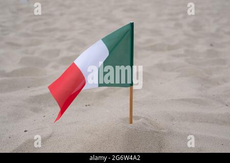 Flagge Italiens auf Sandgrund. Stockfoto