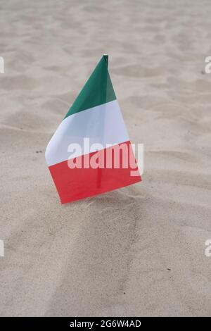 Flagge Italiens auf Sandgrund. Stockfoto