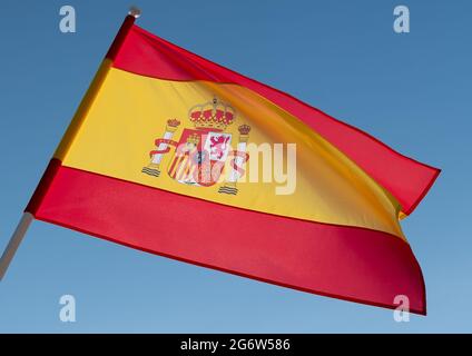 Flagge Spaniens auf blauem Himmel Hintergrund. Spanische Flagge winkt im Wind Stockfoto