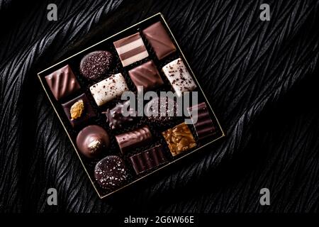 Schweizer Pralinen in Geschenkbox, verschiedene Luxus-Pralinen aus dunkler und milcher Bio-Schokolade in der Schweizer Chocolaterie, süße Dessertspeisen wie Stockfoto
