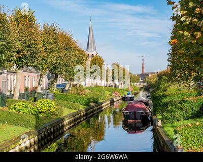 Häuser mit Gärten am Wasser am Kanal Eegracht in der Stadt IJlst, Friesland, Niederlande Stockfoto