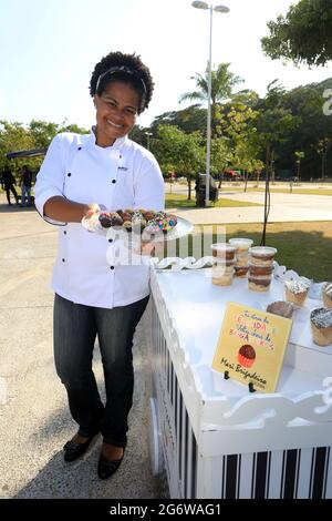 salvador, bahia, brasilien - 28. oktober 2016: Schwarze Frau macht süßes brigadeiro, um es im City Park in Salvador zu verkaufen. *** Ortsüberschrift *** . Stockfoto