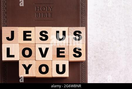 Jesus liebt dich, geschrieben in Blöcken auf einer Holy Bible aus braunem Leder Stockfoto