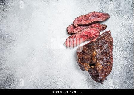 Gebratener Aufhänger oder Onglet-Rindersteak in Scheiben auf einem Tisch. Weißer Hintergrund. Draufsicht. Speicherplatz kopieren Stockfoto