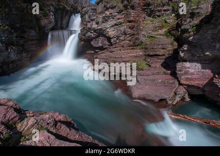 Saint Mary's Falls und Regenbogen im Glacier National Park Stockfoto