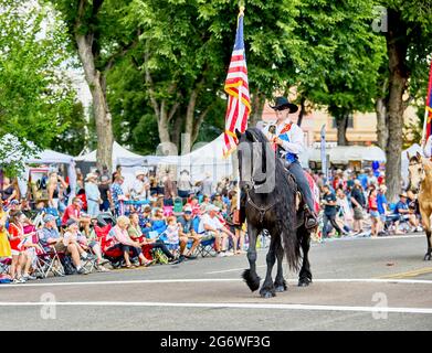 Prescott, Arizona, USA - 3. Juli 2021: Reiter mit amerikanischer Flagge auf dem Pferderücken bei der Parade am 4. Juli Stockfoto