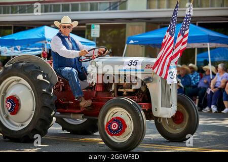 Prescott, Arizona, USA - 3. Juli 2021: Mann auf einem antiken Traktor bei der Parade am 4. Juli Stockfoto