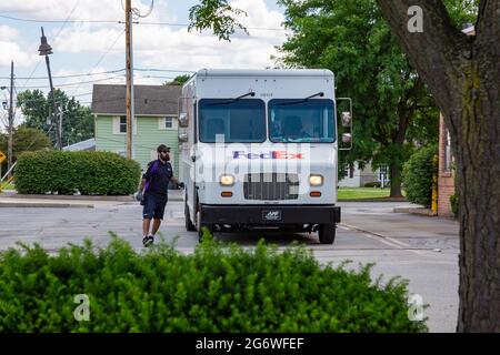 Ein FedEx-Zustellfahrer verlässt sein Fahrzeug auf einem Parkplatz in Fishers, Indiana, USA. Stockfoto