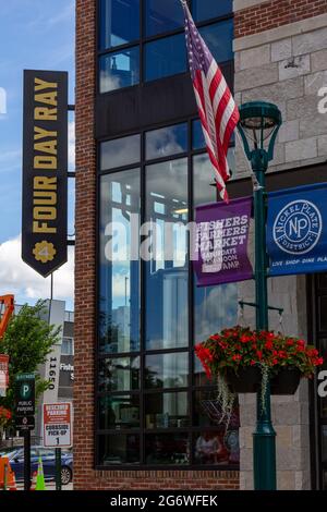 Die Flagge der Vereinigten Staaten hängt an einem Laternenpfahl vor dem Four Day Ray Brewing Pub im Nickel Plate District von Fishers, Indiana, USA. Stockfoto