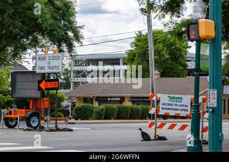 Hinter diesen Straßenschildern in Fishers, Indiana, USA, ist eine im Bau befindliche Parkgarage zu sehen. Stockfoto