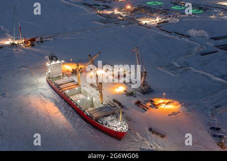 Sabetta, Region Tjumen, Russland - 07. Dezember 2020:das Schiff ist im Frachtbetrieb am Liegeplatz tätig. Das Schiff ist im Eis eingefroren. Stockfoto