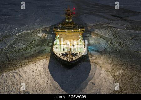 Sabetta, Region Tjumen, Russland - 04. Dezember 2020:der Eisbrecher liegt nachts im Eis. Der Eisbrecher leuchtet mit allen Lichtern. Stockfoto