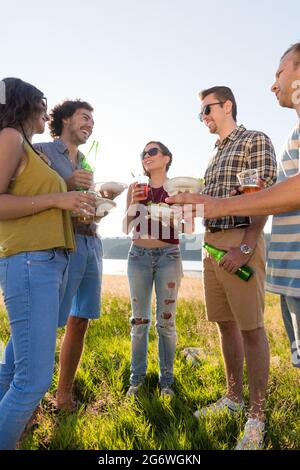 Kreis der Freunde auf Sommer BBQ party am Lakeside in Burger und Bier Stockfoto