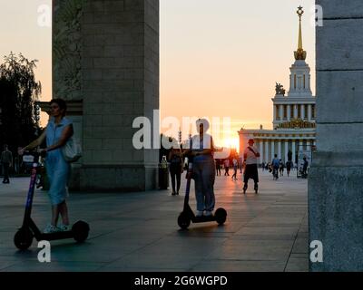 Moskau, Russland. Juli 2021. Menschen auf Motorroller verlassen die Ausstellung der Errungenschaften der Volkswirtschaft. Die abnorme Hitze kehrt in die Region Moskau, die Tagestemperatur ab Donnerstag wird 30 Grad überschreiten, nach der Website des Hydrometeorologischen Zentrums von Russland. Kredit: SOPA Images Limited/Alamy Live Nachrichten Stockfoto