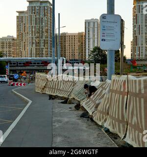 Moskau, Russland. Juli 2021. Eine ältere Frau geht bei Sonnenuntergang hinter dem Straßenbauzaun hinaus. Die abnorme Hitze kehrt in die Region Moskau, die Tagestemperatur ab Donnerstag wird 30 Grad überschreiten, nach der Website des Hydrometeorologischen Zentrums von Russland. (Foto von Mihail Siergiejevicz/SOPA Images/Sipa USA) Quelle: SIPA USA/Alamy Live News Stockfoto