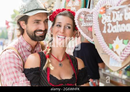 Paar in der richtigen Tracht kaufen Lebkuchenherzen der bayerischen Messe Stockfoto