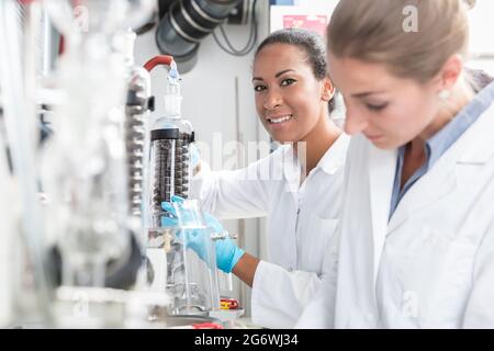 Gruppe von Wissenschaftlern, die im Labor mit Handschuhen und Kittel arbeiten Stockfoto