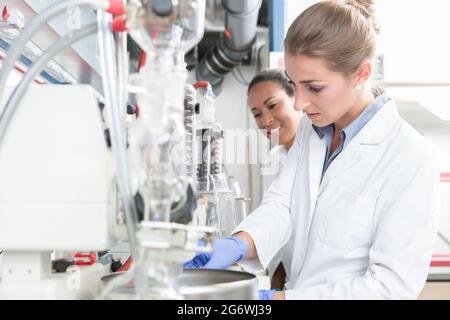 Gruppe von Wissenschaftlern mit Handschuhen und Kleidern im Labor, die Eperiment machen Stockfoto