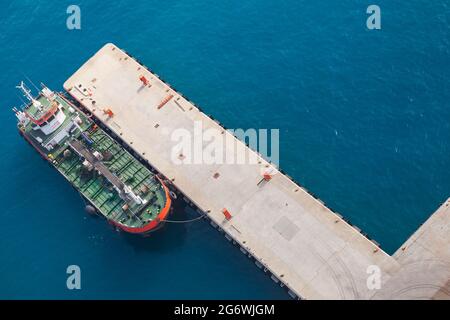 An einem sonnigen Tag, Saudi-Arabien, liegt ein Tankschiff mit grünem Deck im Hafen von Jedda vor Anker. Luftaufnahme Stockfoto