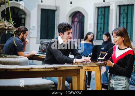 Junge lateinamerikanische Universitätsstudenten verbringen ihre Freizeit am College in Lateinamerika Stockfoto