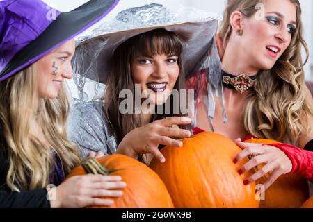 Drei junge und schöne Frauen, lustige Kostüme als Hexen ihre schädliche Kräfte an Halloween Stockfoto