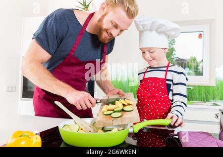 Vater und Sohn essen gemeinsam in der Küche Stockfoto