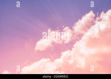Nahaufnahme der Fantasie von Wolken und Himmel mit pastellfarbenem Hintergrund bei Sonnenuntergang, Lichtstrahlen aus der Wolke, leerer Raum für Text. Stockfoto