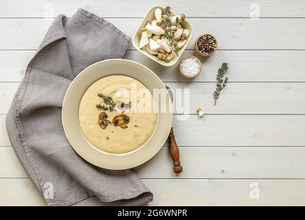 Teller mit köstlicher Pilzsahnesuppe mit Thymian auf dem Holztisch. Horizontale Draufsicht von oben, Kopierbereich Stockfoto