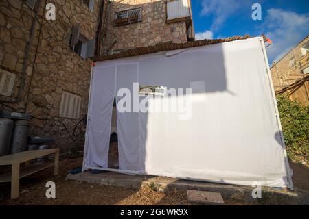 jerusalem-israel, 04-10-2020. Eine Sukkah ist mit einem weißen Blatt im Hof eines Hauses in Jerusalem bedeckt Stockfoto