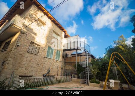 Eine kleine und schmale Sukkah am Eingang zu einem schönen zweistöckigen Haus in Jerusalem, Israel. Stockfoto