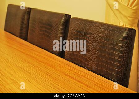 Modernes Zuhause und Nussbaum Esstisch und Ledersessel Detail Stockfoto