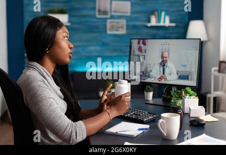 afroamerikanischer Patient mit Medizin Termin diskutieren Pillen Gesundheitsversorgung Behandlung mit Arzt während Online-Videocall Telemedizin. Schwarzer Student mit Atemwegserkrankung Stockfoto