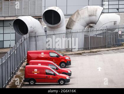 Sheffield South Yorkshire 5.7.2021 leuchtend rote königliche Briefwagen parkten vor seltsamen, großen, modernen Gebäudehüffrohren. Streikenden Postdienst Stockfoto