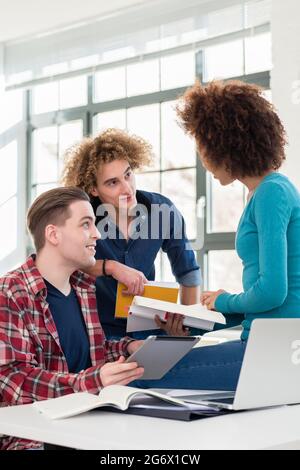 Drei beteiligten Schüler Austausch von Ideen und Meinungen zu verschiedenen Themen und neue Informationen während der Kurse an der Universität gelernt Stockfoto