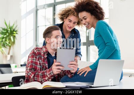 Drei beteiligten Schüler Austausch von Ideen und Meinungen zu verschiedenen Themen und neue Informationen während der Kurse an der Universität gelernt Stockfoto